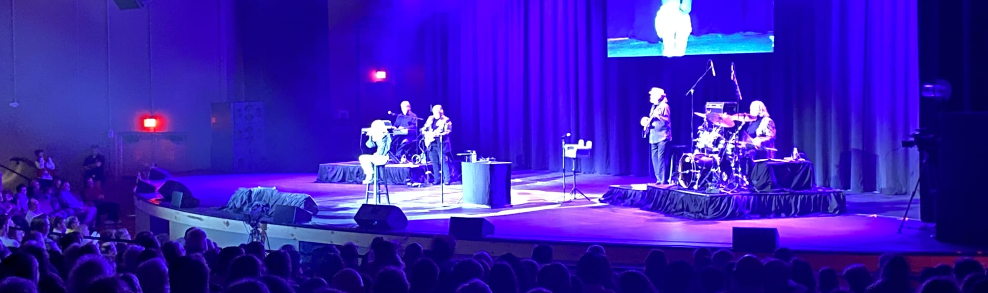 signer on stage in chair washed out by the lights Baltimore